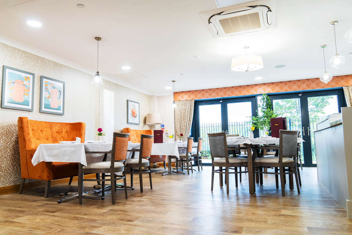 A view of all the tables and chairs laid ready for service in the dining area at Alexandra Mill Care Home.