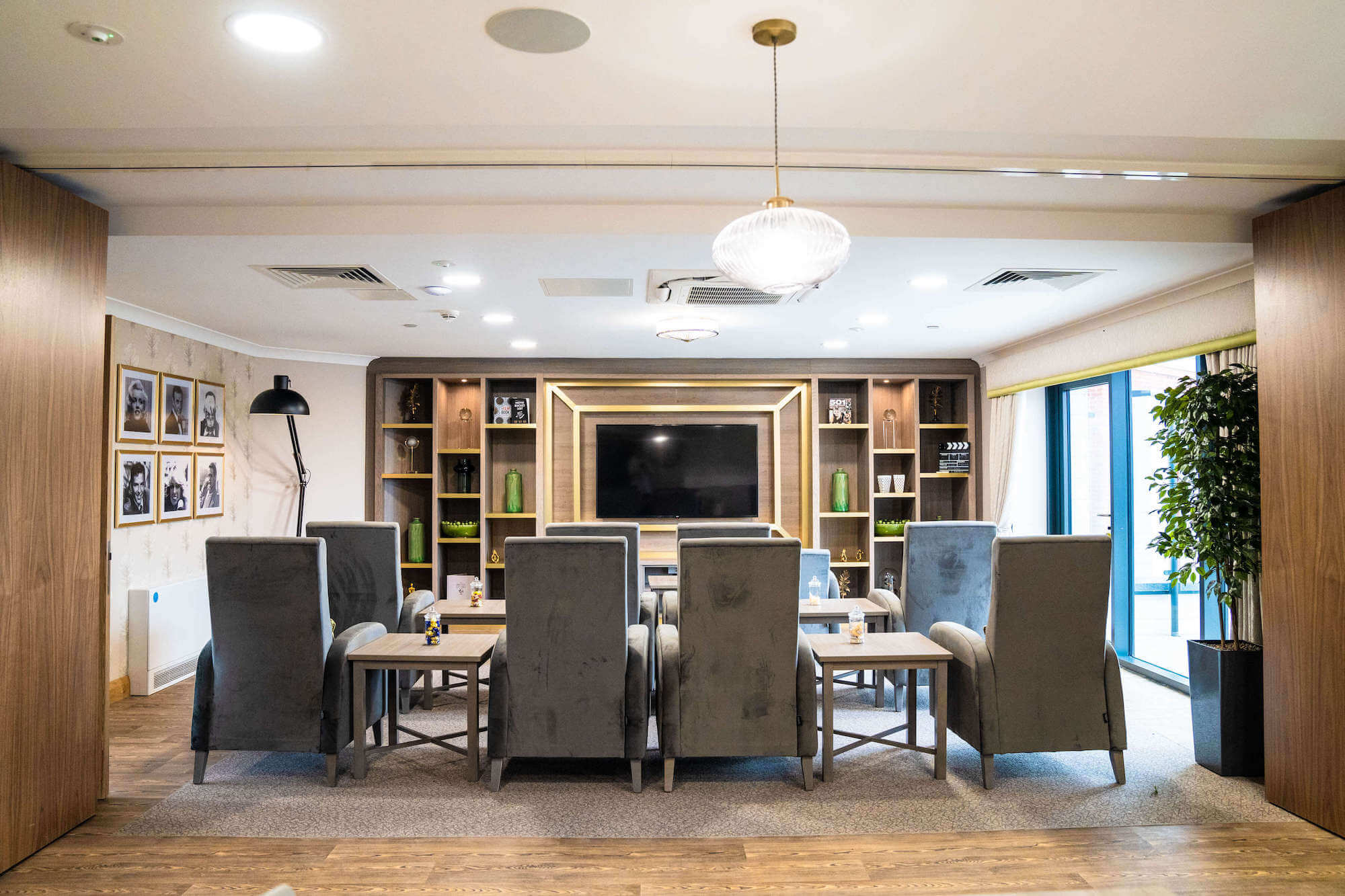 The cinema screen and seating in the cinema and audio visual room at Alexandra Mill Care Home.