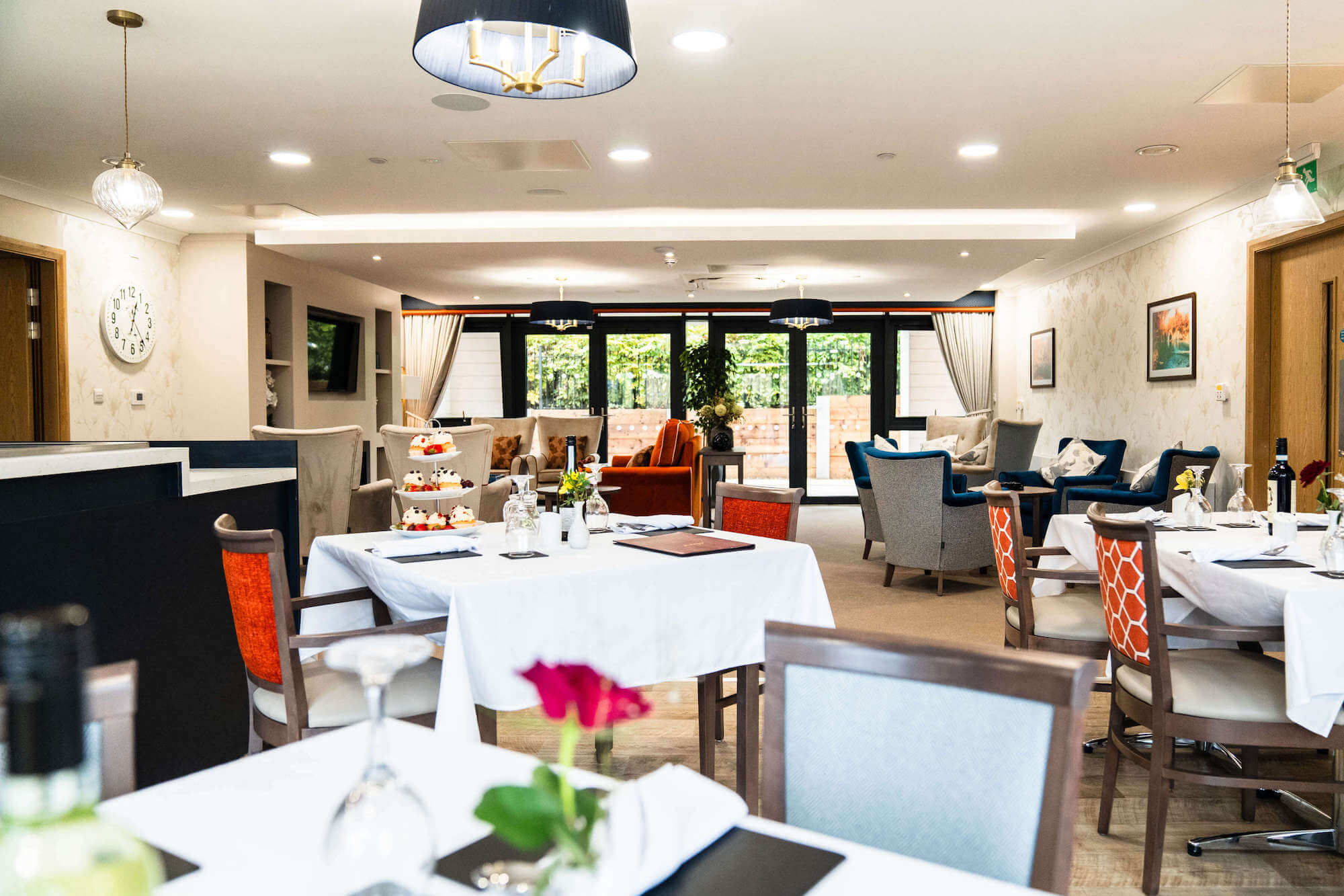 Tables laid with flowers and table clothes in the dining room at Alexandra Mill Care Home.