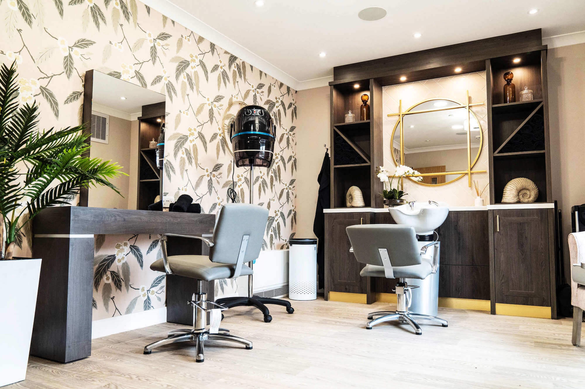 Salon seats, hair dryer and hair washing basin in the Hair and beauty salon at Alexandra Mill Care Home.