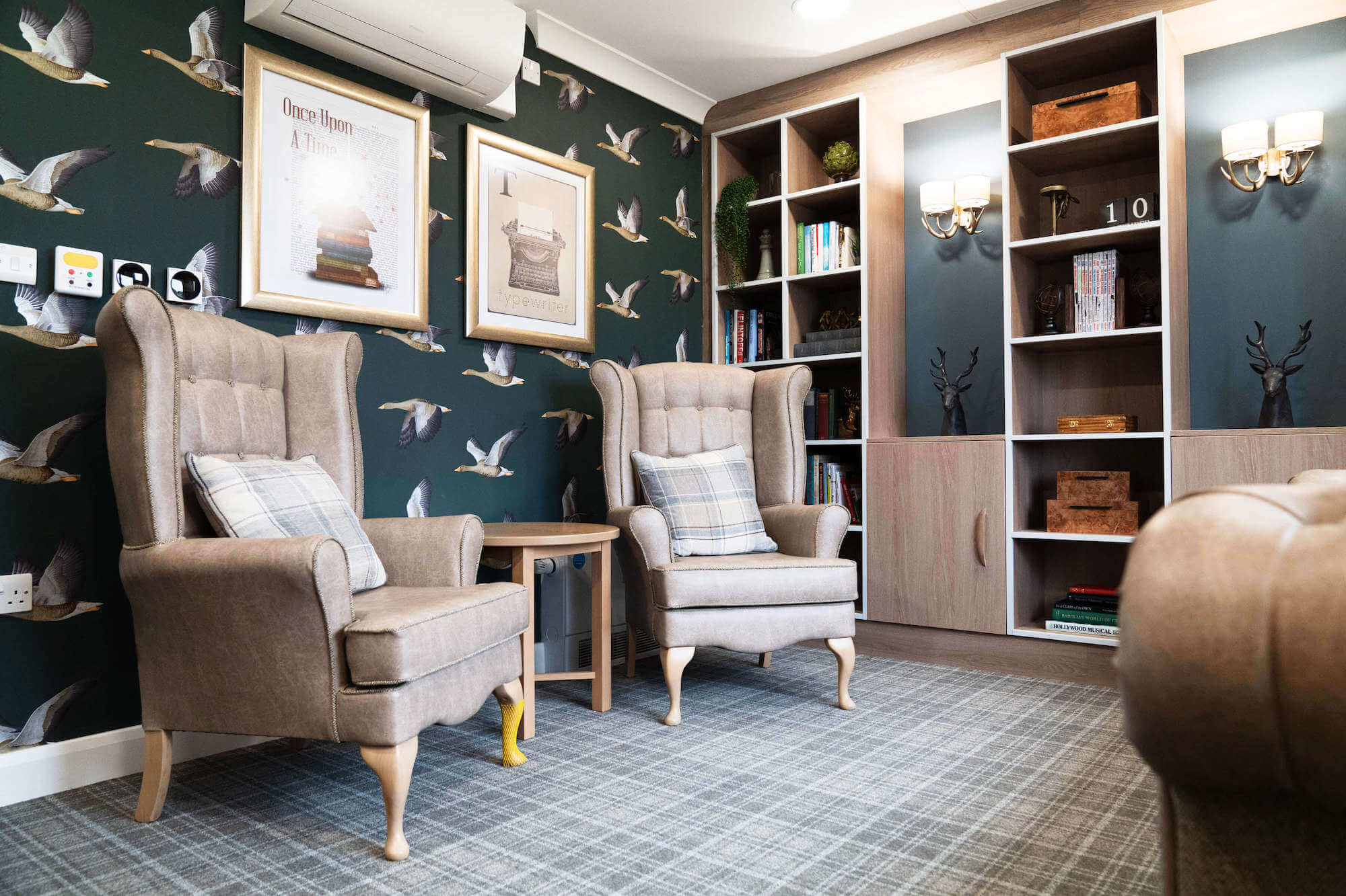 Armchairs and bookshelves in the library at Alexandra Mill Care Home.